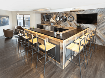 A modern kitchen with a wooden island and bar stools.